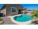 Beautiful backyard featuring a sparkling pool, lush landscaping, and a covered patio for outdoor living and entertaining at 13455 N 142Nd Ave, Surprise, AZ 85379