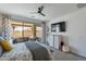 Bright bedroom with fan, dresser, TV, access to patio with seating and pool views at 13455 N 142Nd Ave, Surprise, AZ 85379