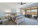 Cozy bedroom features neutral tones, ceiling fan, and sliding glass door leading to the patio at 13455 N 142Nd Ave, Surprise, AZ 85379