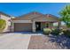 Charming single-story home featuring a well-manicured lawn, desert landscaping, and a two-car garage at 13455 N 142Nd Ave, Surprise, AZ 85379