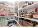 Organized walk-in pantry featuring white shelving with an assortment of goods in baskets at 13455 N 142Nd Ave, Surprise, AZ 85379