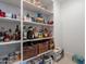 Organized walk-in pantry with white shelves, wicker baskets, beverages, and dry goods at 13455 N 142Nd Ave, Surprise, AZ 85379