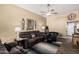 Cozy living room with comfortable seating, ceiling fan, stylish decor, and wood-look flooring at 14212 N Newcastle Dr, Sun City, AZ 85351