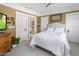 Bedroom featuring a white comforter, tan walls, and white trim, complemented by a ceiling fan at 144 W Palm Ln, Phoenix, AZ 85003