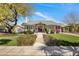 Charming single-story home with lush landscaping and a welcoming red front door at 144 W Palm Ln, Phoenix, AZ 85003
