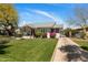 Well-manicured lawn leads to the charming home featuring a red door and inviting porch at 144 W Palm Ln, Phoenix, AZ 85003