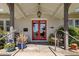 Cozy front porch with seating, potted plants, and a bright red double-door entrance at 144 W Palm Ln, Phoenix, AZ 85003