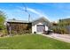 View of the property's rear yard with a detached garage and outdoor seating area at 144 W Palm Ln, Phoenix, AZ 85003