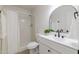 Modern bathroom features a shower-tub combo, updated vanity, black fixtures, and a stylish round mirror at 14803 N 55Th Ave, Glendale, AZ 85306
