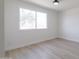 A spacious bedroom with modern light fixture and a window with view of a tree outside at 14803 N 55Th Ave, Glendale, AZ 85306