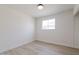 An empty, bright bedroom with light wood-look floors showcases a window providing natural light and ventilation at 14803 N 55Th Ave, Glendale, AZ 85306