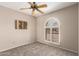 Bedroom features a ceiling fan, neutral paint, and a unique arched window at 15022 N 22Nd Ln, Phoenix, AZ 85023