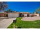Charming single-story home boasts a well-manicured lawn, complemented by gravel landscaping and a two-car garage at 15022 N 22Nd Ln, Phoenix, AZ 85023
