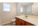 Bathroom featuring window, sink, wooden cabinets, mirror, faucet, toilet and tub/shower creating a bright and inviting space at 18123 W Lundberg St, Surprise, AZ 85388