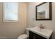 Powder room featuring a modern vanity with a black cabinet and a framed mirror at 18123 W Lundberg St, Surprise, AZ 85388