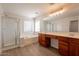 Bright bathroom with double sinks, a glass shower, and a soaking tub complemented by wood-look floors at 18123 W Lundberg St, Surprise, AZ 85388