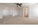 Spacious bedroom with neutral carpet, ceiling fan, and arched doorways for a modern and bright feel at 18123 W Lundberg St, Surprise, AZ 85388