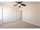 Bright, carpeted bedroom with ceiling fan, closet and doorway providing a bright and inviting atmosphere at 18123 W Lundberg St, Surprise, AZ 85388