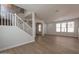 Bright, open living room with wood-look flooring, a staircase, and large windows allowing ample natural light at 18123 W Lundberg St, Surprise, AZ 85388