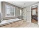 Bright bathroom featuring a separate tub and glass shower with a window for natural light at 18572 N 94Th St, Scottsdale, AZ 85255