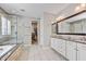 Bright bathroom with double vanity, large mirror, separate tub, and glass shower at 18572 N 94Th St, Scottsdale, AZ 85255
