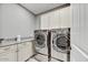 Well-equipped laundry room with modern, stainless steel appliances, granite countertops, and ample cabinet space at 18572 N 94Th St, Scottsdale, AZ 85255