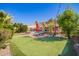 Beautiful backyard with putting green, fire pit, pool, and comfortable lounge chairs, perfect for outdoor entertaining at 21256 E Waverly Dr, Queen Creek, AZ 85142