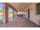 Spacious covered patio featuring ceiling fans, brick flooring, and comfortable seating, perfect for outdoor relaxation at 21256 E Waverly Dr, Queen Creek, AZ 85142