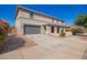 Wide view of a large home showcasing a gray garage door and a neatly landscaped front yard at 21256 E Waverly Dr, Queen Creek, AZ 85142