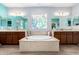 Luxurious bathroom with a soaking tub, dual vanities, and a stained glass window at 21256 E Waverly Dr, Queen Creek, AZ 85142
