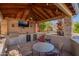 Outdoor kitchen and dining area complete with grill, bar, TV, and comfortable seating, perfect for entertaining at 21256 E Waverly Dr, Queen Creek, AZ 85142