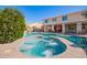 Inviting backyard pool and spa with red umbrellas in a two-story home offers relaxation and entertainment at 21256 E Waverly Dr, Queen Creek, AZ 85142