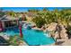 Resort-style pool area with a water slide, built-in bar, waterfall, and lounge chairs at 21256 E Waverly Dr, Queen Creek, AZ 85142