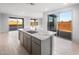 Bright kitchen showcasing an island with granite countertops, cabinets, and stainless steel sink at 21287 N 272Nd Ln, Buckeye, AZ 85396