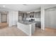 Open concept kitchen features stainless appliances, granite countertops, an island with sink, and light wood-look floors at 21287 N 272Nd Ln, Buckeye, AZ 85396