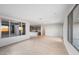 Spacious living room with wood-look flooring, large windows, and seamless flow into kitchen at 21287 N 272Nd Ln, Buckeye, AZ 85396