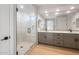 Modern bathroom with a glass shower and gray vanity with black hardware at 21288 N 272Nd Ln, Buckeye, AZ 85396