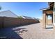 Gravel backyard enclosed with a block wall and view of neighboring houses at 22463 E Rosa Rd, Queen Creek, AZ 85142