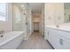 Bright bathroom featuring tiled floors, a modern tub, and a glass enclosed shower at 22463 E Rosa Rd, Queen Creek, AZ 85142
