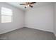 Bedroom features a ceiling fan and a large window that allows for natural light at 22463 E Rosa Rd, Queen Creek, AZ 85142