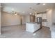 Open concept living space with kitchen island, stainless steel appliances, and light tile floors at 22463 E Rosa Rd, Queen Creek, AZ 85142