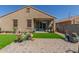 Inviting backyard featuring a covered patio, lush artificial grass, and a charming paver patio area at 2424 S 235Th Dr, Buckeye, AZ 85326