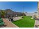 Spacious backyard boasts lush artificial turf, a charming patio, and well-maintained landscaping perfect for outdoor enjoyment at 2424 S 235Th Dr, Buckeye, AZ 85326