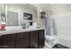 Bathroom featuring dark cabinets, a white countertop, and a shower-tub combo at 2424 S 235Th Dr, Buckeye, AZ 85326