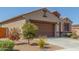 Single-story home showcasing desert landscaping, a paved driveway, and a tile roof at 2424 S 235Th Dr, Buckeye, AZ 85326