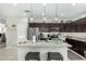 Stylish kitchen with a granite island, stainless steel appliances, and dark wood cabinets at 2424 S 235Th Dr, Buckeye, AZ 85326