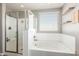 Bright bathroom with a soaking tub, glass-enclosed shower, and floating shelves at 2765 E Gillcrest Rd, Gilbert, AZ 85298