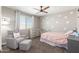Bright bedroom featuring a chair with footstool, dresser, ceiling fan and a white metal bed frame at 2765 E Gillcrest Rd, Gilbert, AZ 85298