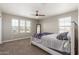 Bright bedroom with a ceiling fan and multiple windows with neutral color scheme and carpet at 2765 E Gillcrest Rd, Gilbert, AZ 85298