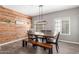 Rustic dining room with wood accent wall, modern lighting, and a dark wood table with bench seating at 2765 E Gillcrest Rd, Gilbert, AZ 85298